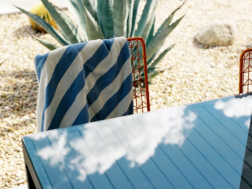 A striped towel sits on a chair at a Palm Springs pool